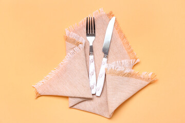 Clean napkin with cutlery on color background