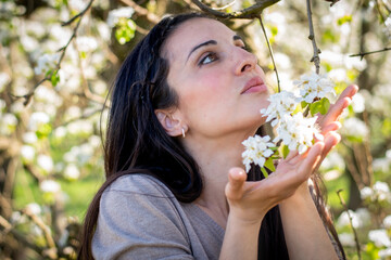 Mujer rodeada de flores en un campo de flores rosas y blancas