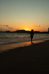 Fototapeta na wymiar beautiful woman enjoying the beach and an incredible sunset against light