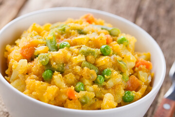 Charquican, a traditional Chilean dish, vegetarian version, made of lightly mashed and mixed potatoes, pumpkin, onion, carrots, peas, corn and green beans (Selective Focus in the middle of the dish)