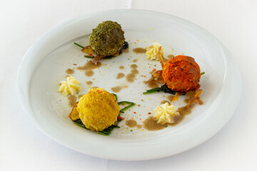 Meatballs of three flavorson a white plate and white background, fine dining, vegetarian dish, gourmet cuisine, healthy mediterranean diet concept, restaurant, close up.