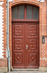 View of brick building with ornate wooden door