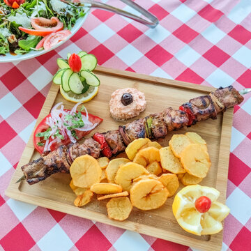Greek kontosouvli large souvlaki made by fresh meat grilled on fire and served with french fries.