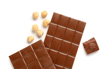 Tasty chocolate and hazelnuts on white background, closeup