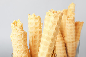 Delicious wafer rolls on grey background
