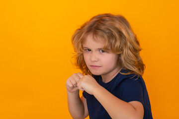 Angry child with fist gesture fight, hit on studio isolated background. Kid boy with mad expression handed punch. Bad kids behavior. Fury boy. Boy fight, battle.