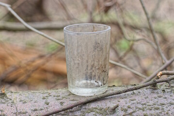 one old gray dirty soviet glass stands on a table in the street 