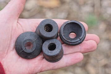 a row of black rubber round spacers for plumbing lie on the palm of your hand