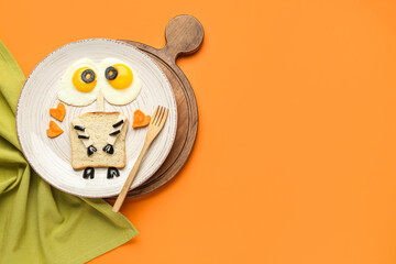 Plate with funny children's breakfast on orange background