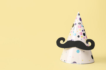 Party hat with paper mustache on color background