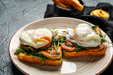Plate with tasty eggs Benedict on black background