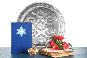Torah, Passover Seder plate, flatbread matza, walnuts and alstroemeria flowers on table against white background