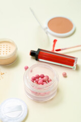 Lipstick with makeup powder on beige background, closeup