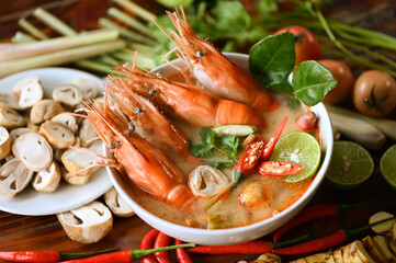 Hot and sour spicy shrimps prawns soup  curry lemon lime galangal red chili straw mushroom on table food, Shrimp soup on seafood soup bowl with thai herb and spices, Thai Food Tom Yum Kung