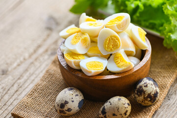 boiled eggs food, quail eggs on wooden bowl, breakfast eggs with fresh quail eggs and vegetable lettuce on table background