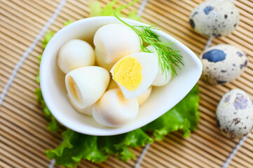 boiled eggs food, quail eggs on white bowl, breakfast eggs with fresh quail eggs and vegetable lettuce on table background - top view