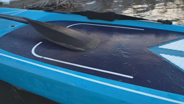 icy deck of stand up paddleboard with a paddle, early spring paddling in Colorado
