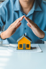 Broker agent with model toy house with documents signed purchase and sale contracts and mortgages including fire insurance