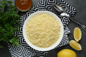 Tasty couscous and ingredients on grey table, flat lay