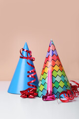 Colorful party hats, streamers and blower on white table. Birthday celebration
