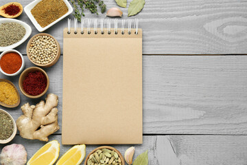 Blank recipe book and different ingredients on grey wooden table, flat lay. Space for text