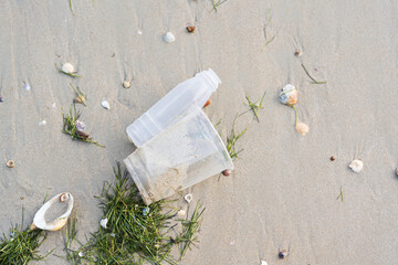 Close up plastic bottle and cup on the sand beach.Save the earth.Environment ecology care and...