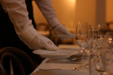 Woman setting table in restaurant, closeup. Professional butler courses