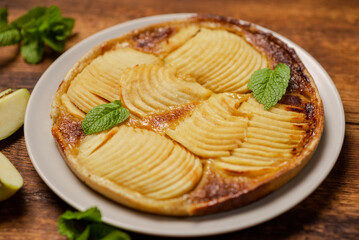 Cooked apple pie on wooden background. Finished semi-finished product.