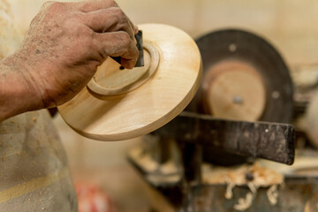 close up senior man sanding wooden plate