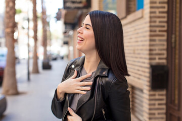 young pretty woman laughing out loud at some hilarious joke, feeling happy and cheerful, having fun