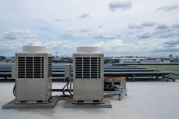 Air conditioner units HVAC on a roof of industrial building with blue sky.