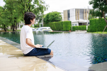 Digital Nomad in Casual Attire Completes Business Tasks Poolside on Vacation