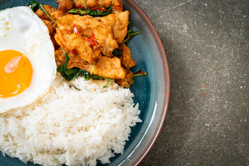 stir-fried fried fish with basil and fried egg topped on rice