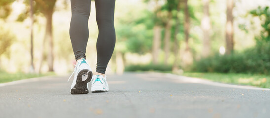 woman jogging and walking on the road at morning, Young adult female in sport shoes running in the...