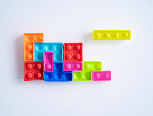 Colorful rubber toy blocks on white glass background 
