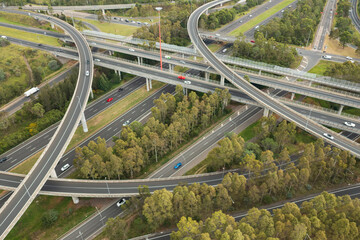 Aerial view of blurred traffic at the Light Horse Interchange junction of M4 and M7 motorways at Eastern Creek in western Sydney, Australia. - obrazy, fototapety, plakaty
