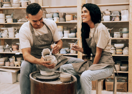 A young couple works in a pottery workshop. Painting a vase. The concept of hobbies, lifestyle and relationships.