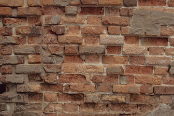 Ancient brick wall has traces of weathering damage over time. Orange and red brick wall texture background.