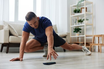 Man sportsman training at home, stretching exercises for arm, leg and back muscles, strong body and...