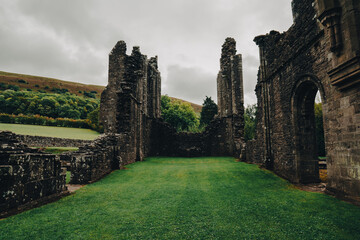 Landmarks of Wales travel concept. View of ancient ruins of the castle/church in Brecon Beacons National Park, United Kingdom.  Llanthony Priory Abbey in the Vale of Ewyas. Llanthony priory ruins. 