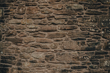 Historic stone wall showcasing traditional Welsh craftsmanship in a rural setting on a cloudy day