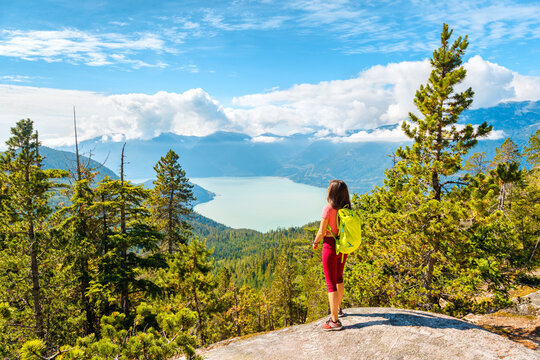 Hiking woman at viewpoint in amazing nature landscape mountain hike. Aspirational outdoor lifestyle photo from Squamish Stawamus Chief Hike, British Columbia, Canada.