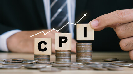 CPI, consumer price index symbol. hand holding wooden block with words CPI, consumer price index on dollar bills. Business and CPI. - obrazy, fototapety, plakaty