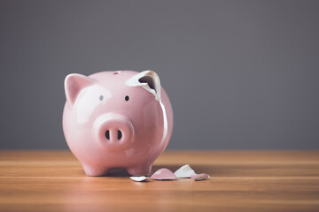 Financial problem fixing, repair or maintenance idea. Pink broken piggy bank on wooden desk with dark background. Financial, Bankrupt or fail in business concept.