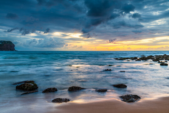 Sunrise with scattered rain clouds at the seaside