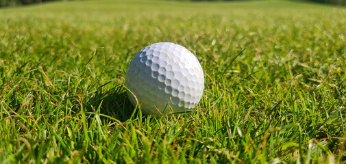 Golf ball on green grass of golf course copy space