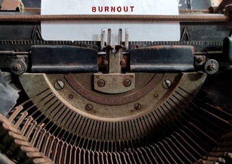 Fototapeta na wymiar Vintage typewriter with text typed BURNOUT , state of emotional, physical, and mental exhaustion caused by excessive and prolonged stress