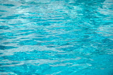Obraz premium Water background, ripple waves. Blue swiming pool pattern. Sea surface. Water in swimming pool with sun reflection. Banner with copy space.