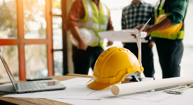Engineer teams meeting working together wear worker helmets hardhat on construction site in modern city.Asian industry professional team.