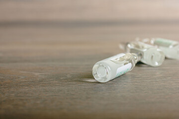 Medicine ampoules lie on a wooden background